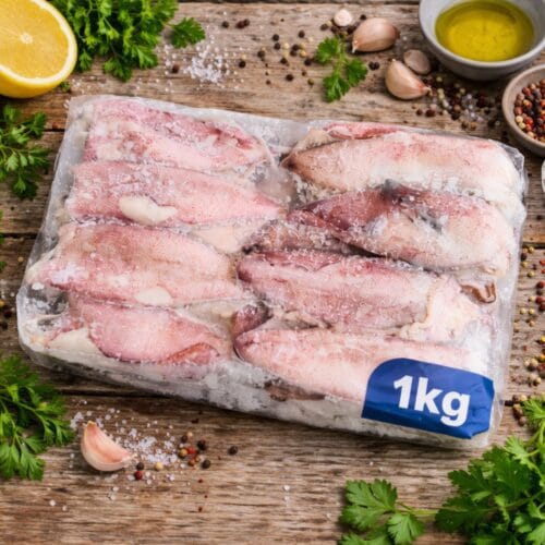 Καλαμαράκια κατεψυγμένα ολόκληρα συσκευασία 1 κιλό σε rustic ξύλινο τραπέζι με λεμόνι μαϊντανό και ελαιόλαδο